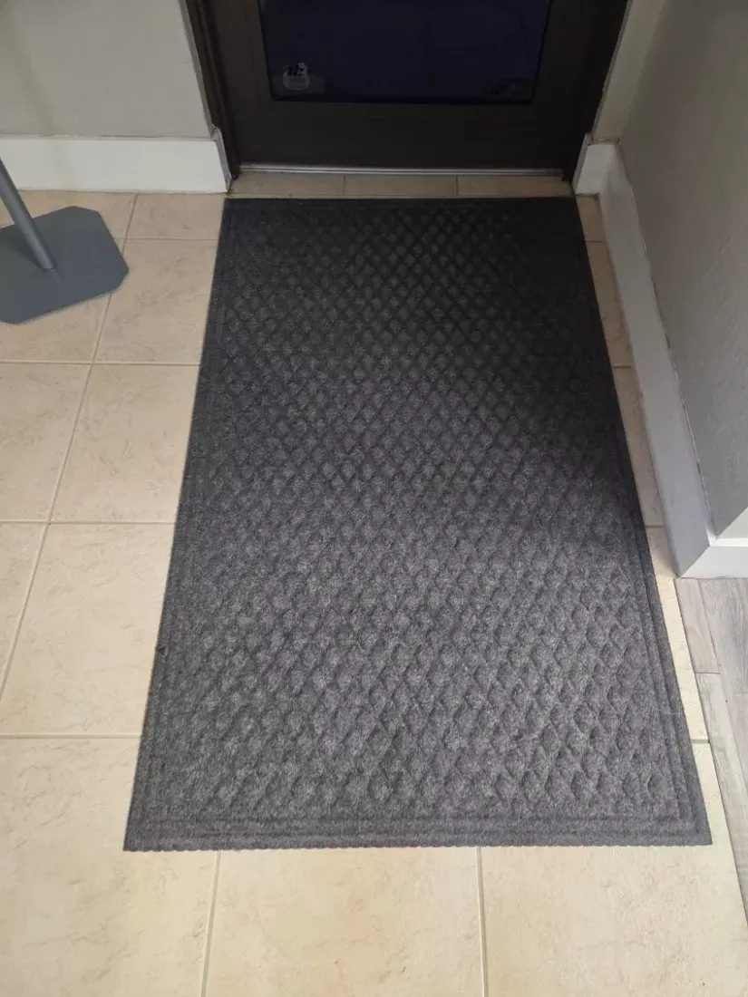 Entry tile mopped and the walk-off mat vacuumed at a clinic doorway